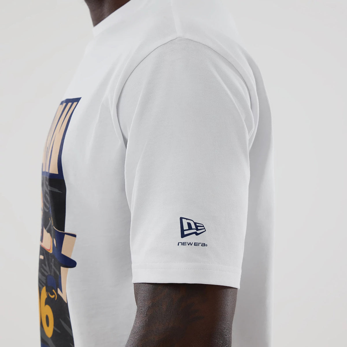 New Era Williams Japan 1996 White Oversized T-Shirt, side view on-model showcasing the large printed graphic on the front, short sleeves featuring a blue embroidered New Era logo near the hem, and a relaxed cut highlighting the design.