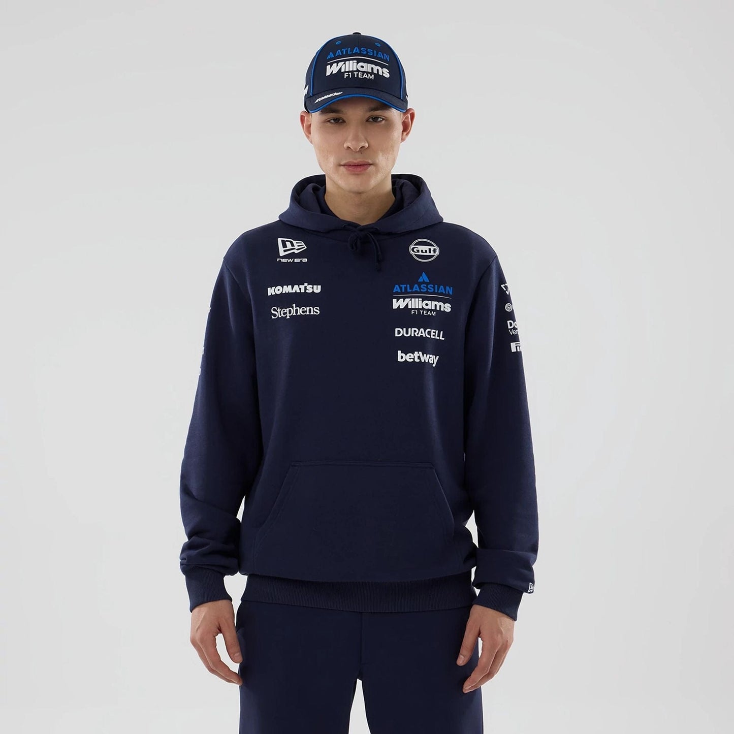 The model is wearing this Replica Atlassian Williams F1 Team Pullover Hoodie in navy. 1