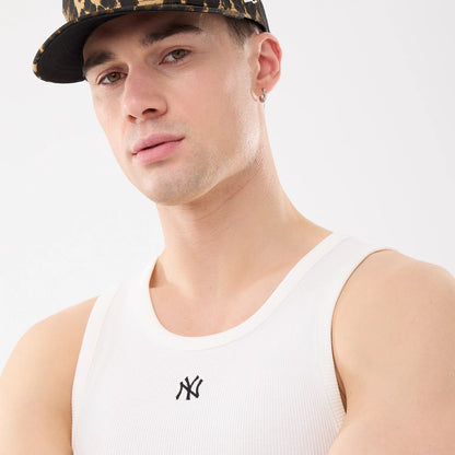 New Era New York Yankees MLB Rib White Vest, on-model view with the black embroidered NY Yankees logo centred on the chest of the white ribbed fabric, complemented by the model wearing a leopard-print cap and a silver hoop earring.
