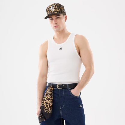 New Era New York Yankees MLB Rib White Vest, front view on a model styled with a leopard print cap, featuring a black NY logo embroidered on the chest of the white ribbed fabric, paired with dark jeans.