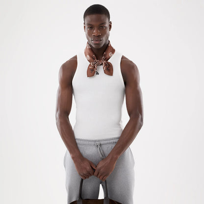 New Era LA Dodgers MLB Rib White Vest, front view on a model wearing a brown patterned scarf, showing the ribbed texture and the black LA logo embroidered on the chest, paired with light grey drawstring trousers.