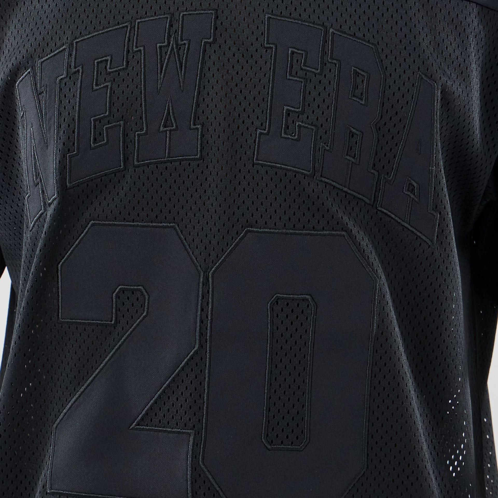 The model is wearing this New Era Mesh Oversized T-Shirt in black. 4