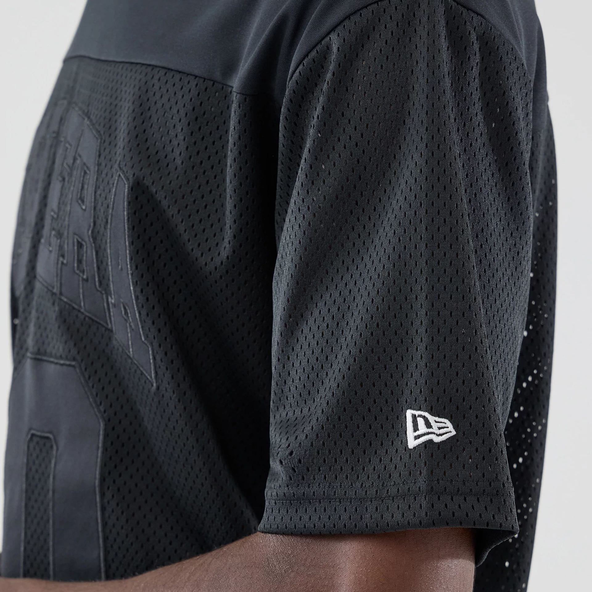 The model is wearing this New Era Mesh Oversized T-Shirt in black. 5