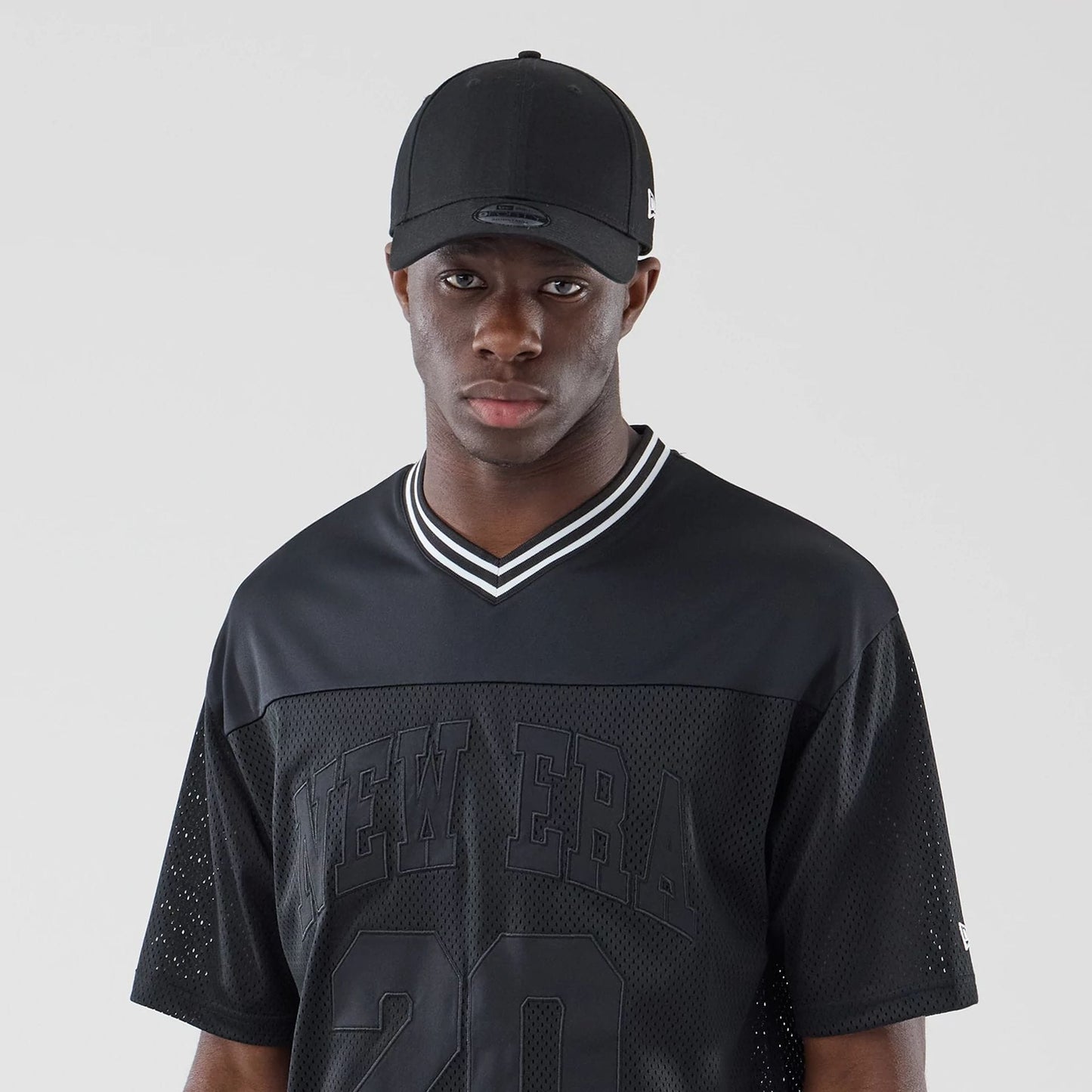 The model is wearing this New Era Mesh Oversized T-Shirt in black. 6