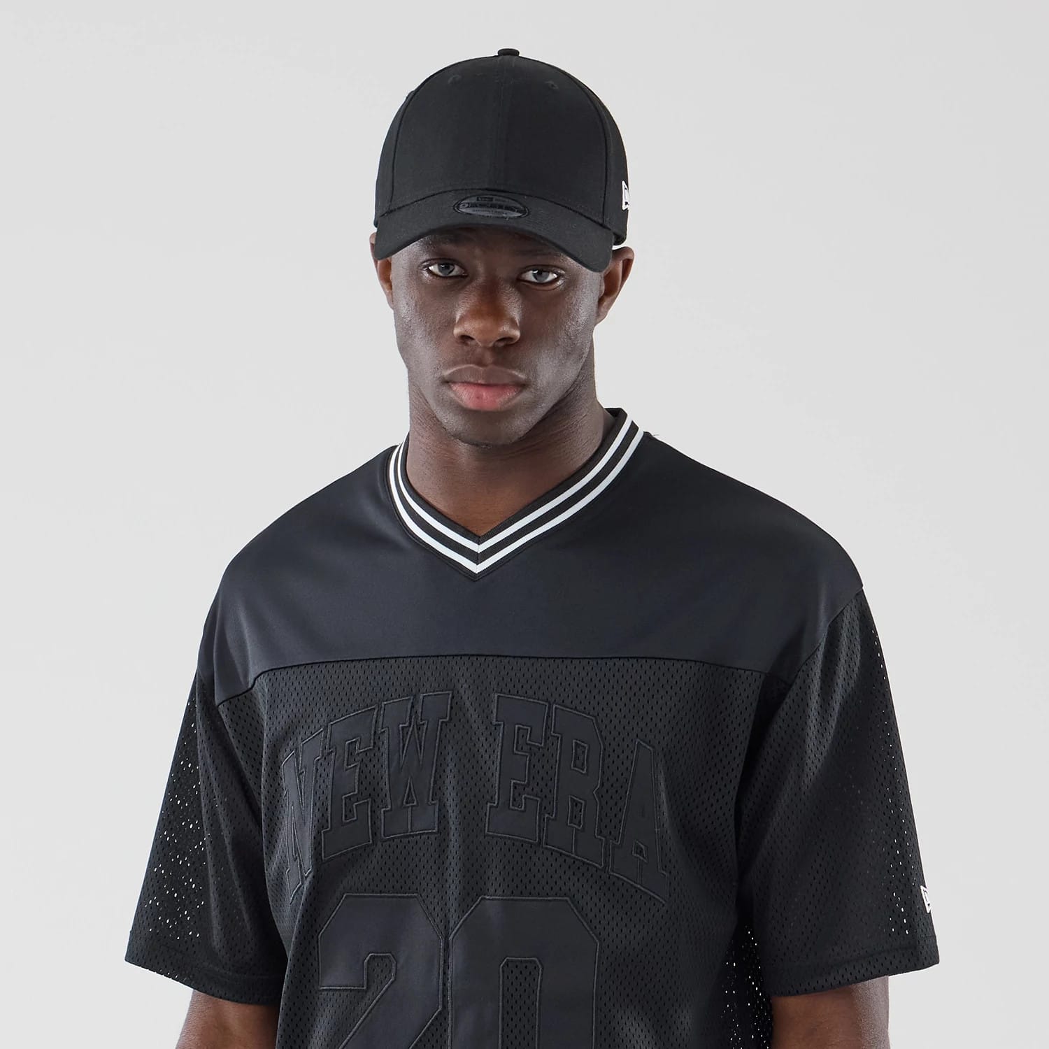The model is wearing this New Era Mesh Oversized T-Shirt in black. 6