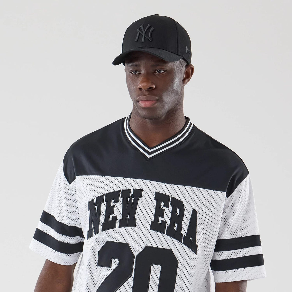 The model is wearing this New Era Mesh Oversized T-Shirt in white. 6