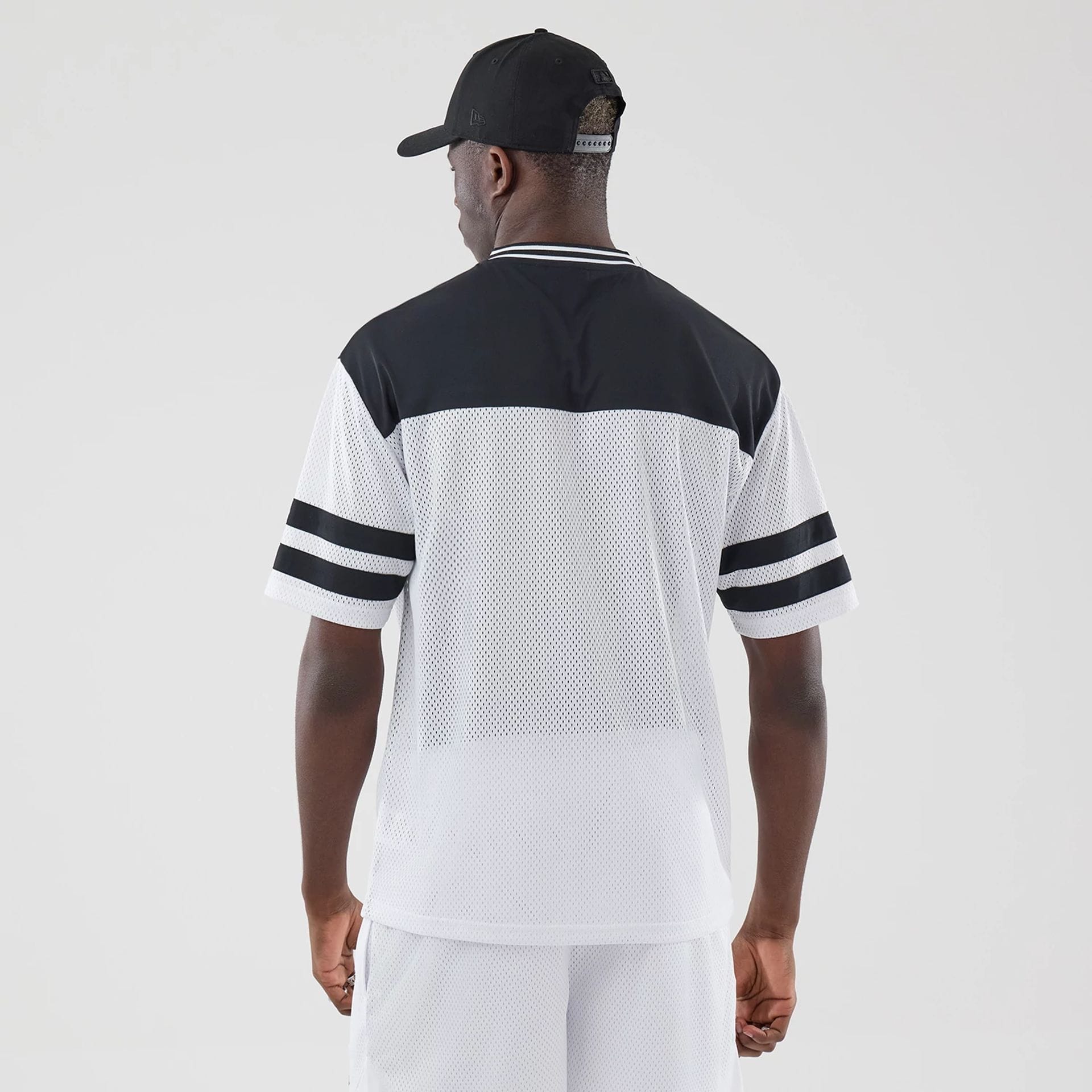 The model is wearing this New Era Mesh Oversized T-Shirt in white. 2