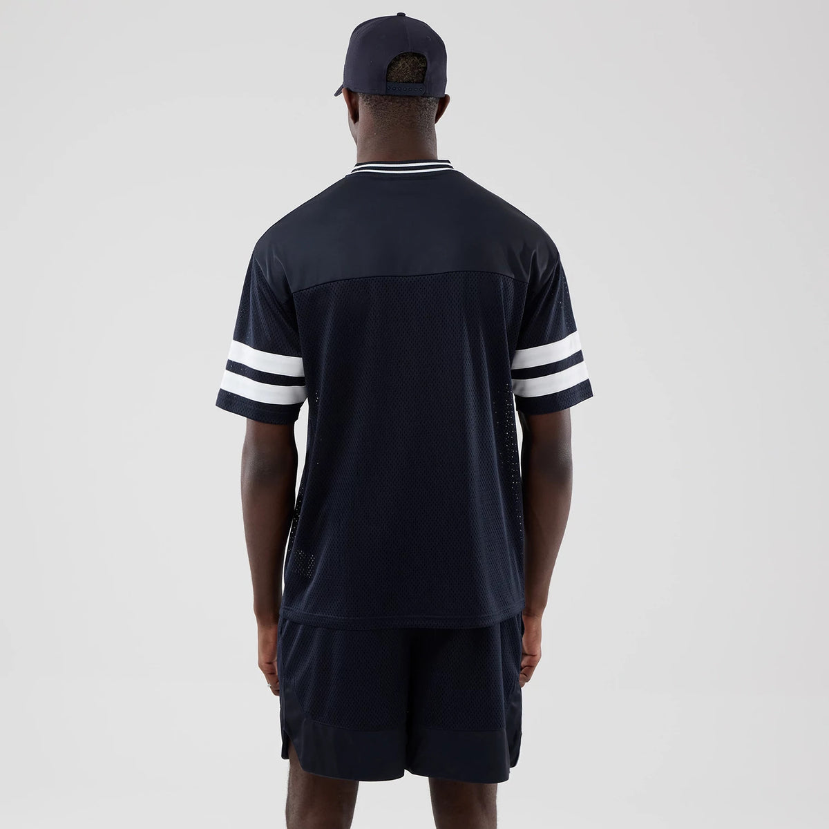 The model is wearing this New Era Mesh Oversized T-Shirt in navy. 2