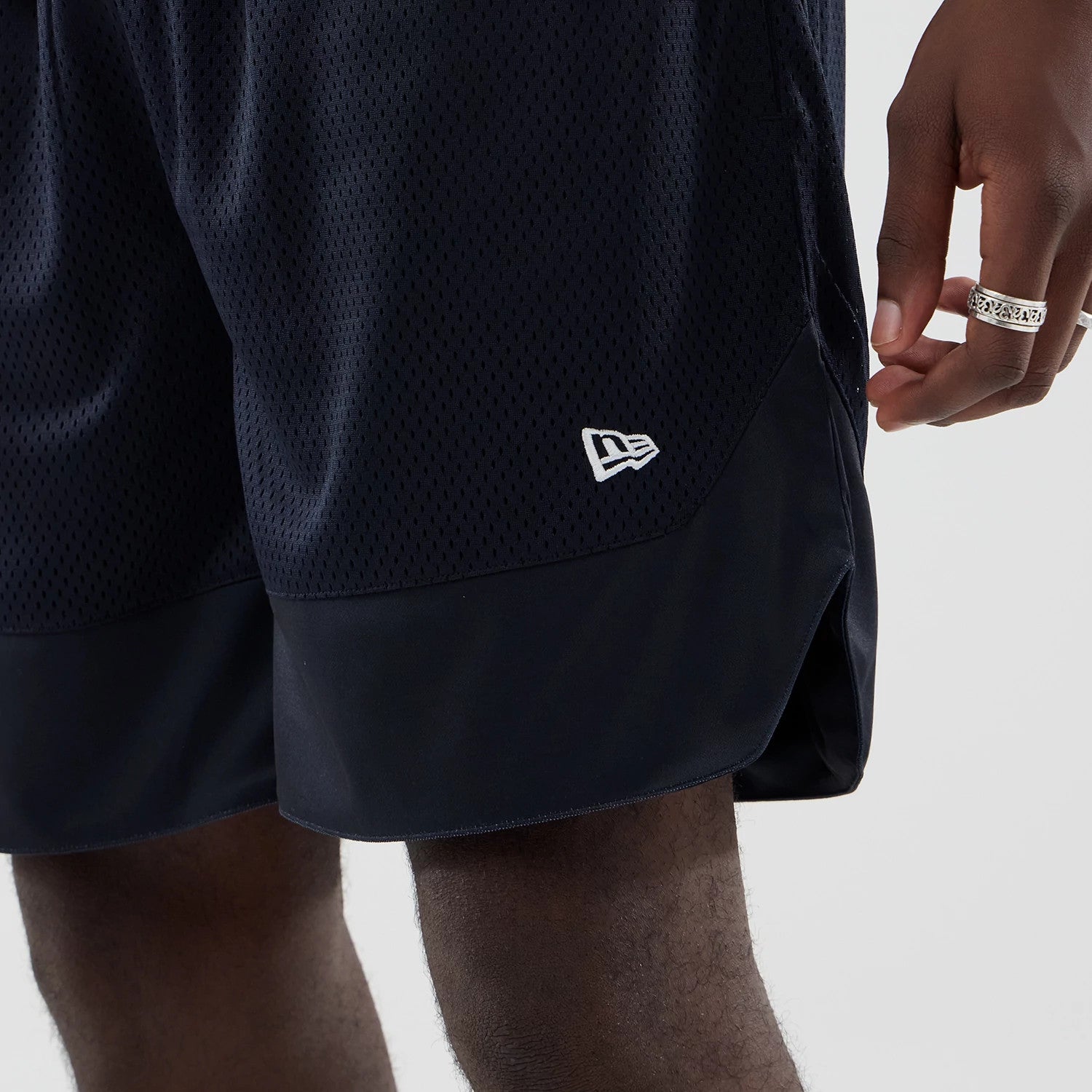 The model is wearing this New Era Mesh Oversized Shorts in navy. 4