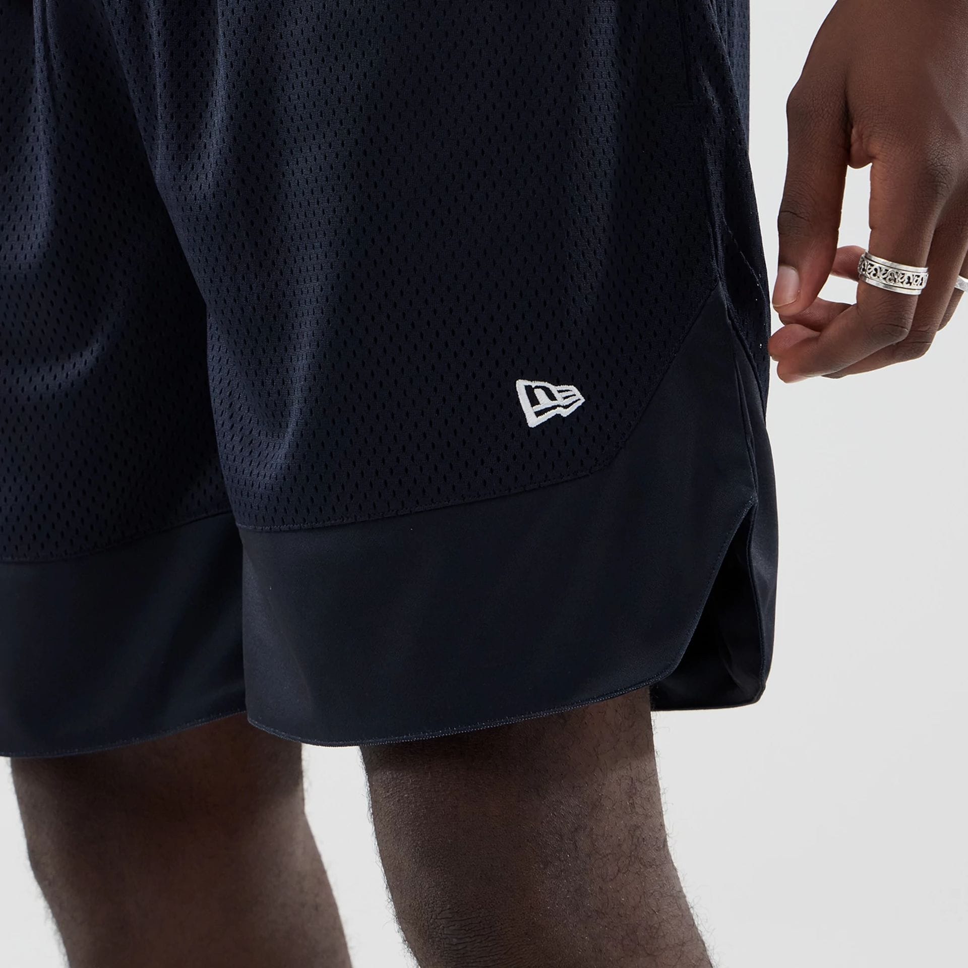 The model is wearing this New Era Mesh Oversized Shorts in navy. 4