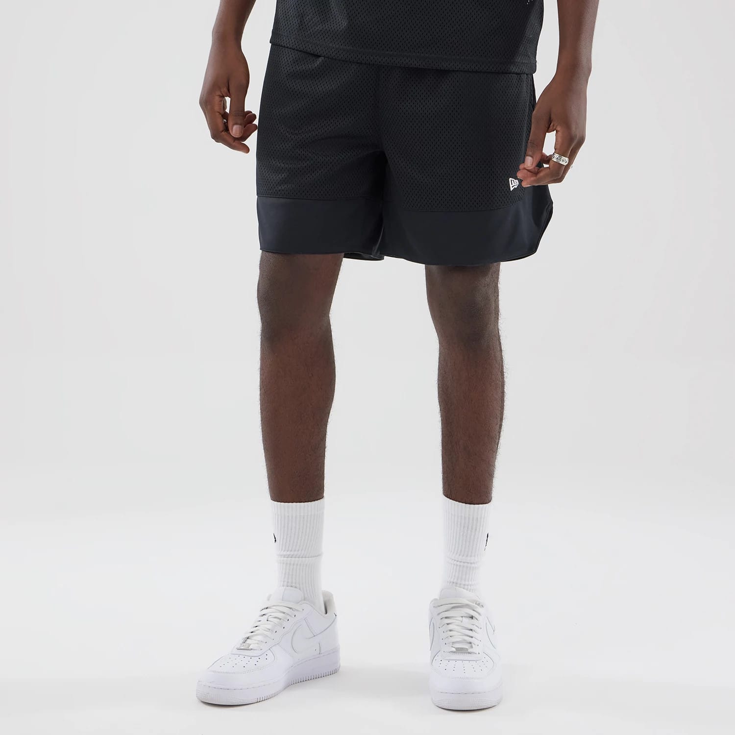 The model is wearing this New Era Mesh Oversized Shorts in black. 3