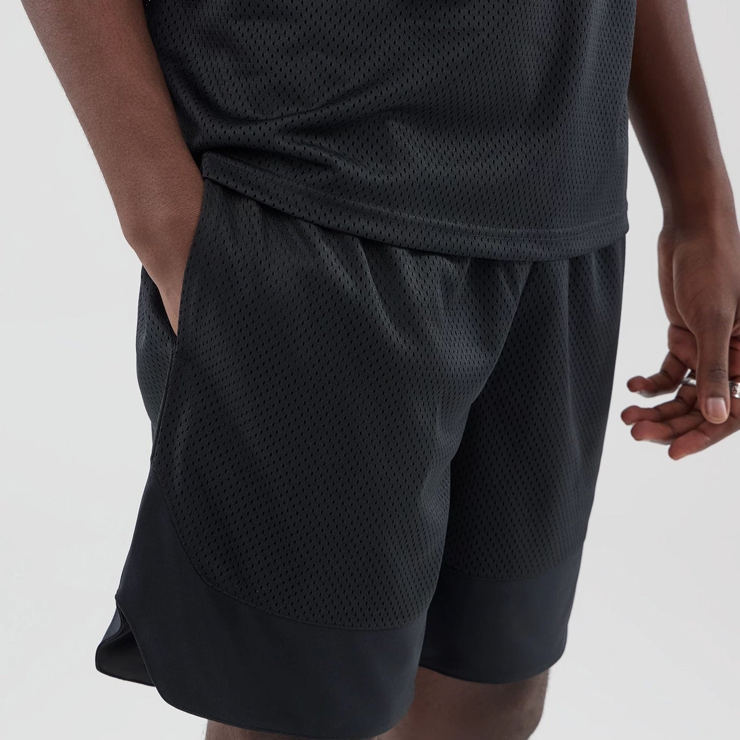 The model is wearing this New Era Mesh Oversized Shorts in black. 4