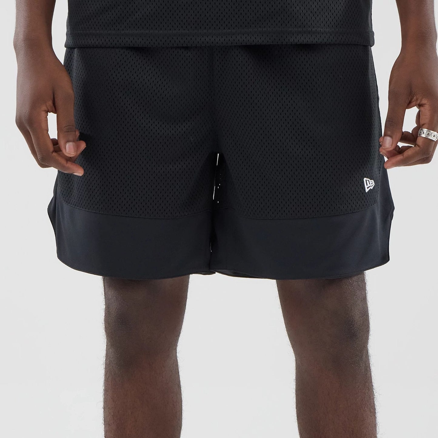 The model is wearing this New Era Mesh Oversized Shorts in black. 6