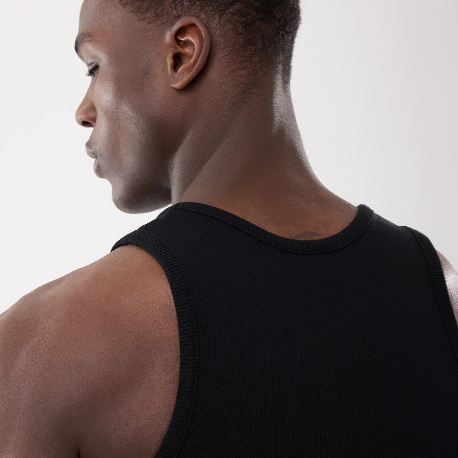 The model is wearing this New Era Rib Vest in black. 11