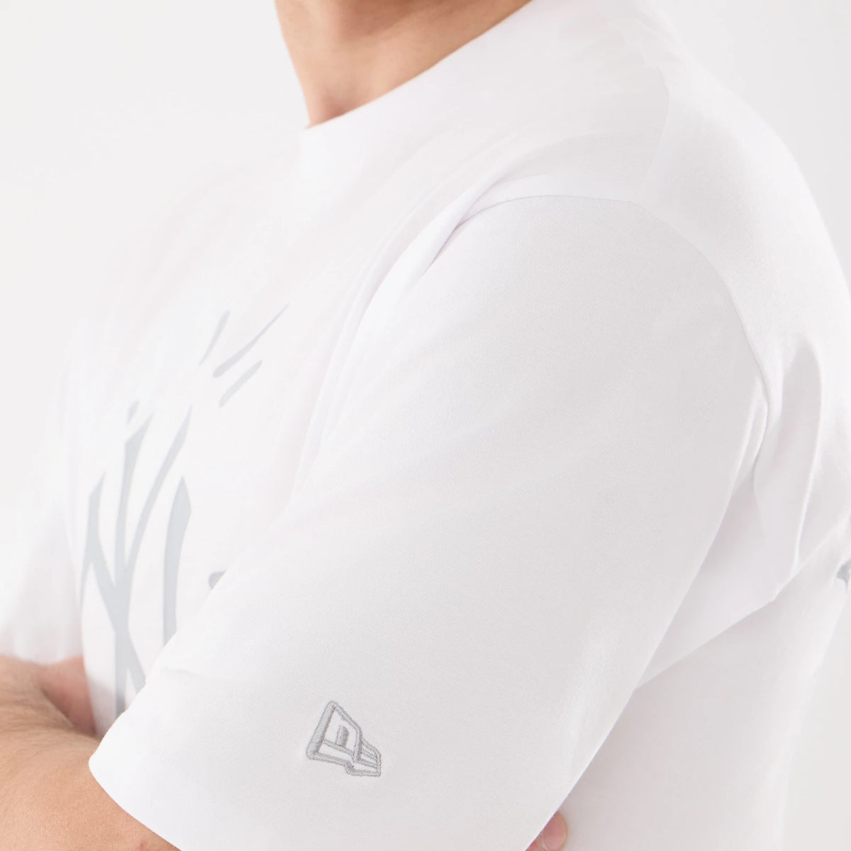 New Era New York Yankees MLB 59FIFTY Day Graphic White T-Shirt, three-quarter view showing part of the grey New York Yankees logo on the chest and a small embroidered New Era logo near the sleeve hem on the white fabric.