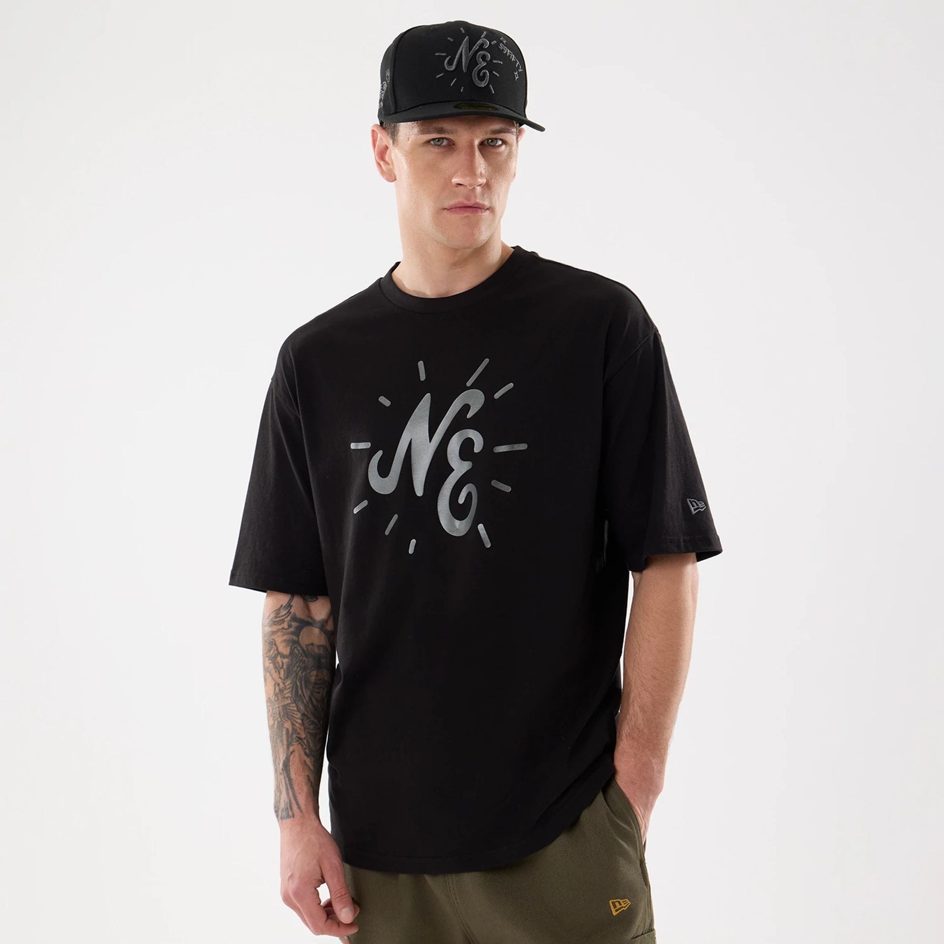 The model is wearing this New Era 59FIFTY Day Graphic T-Shirt in black. 1