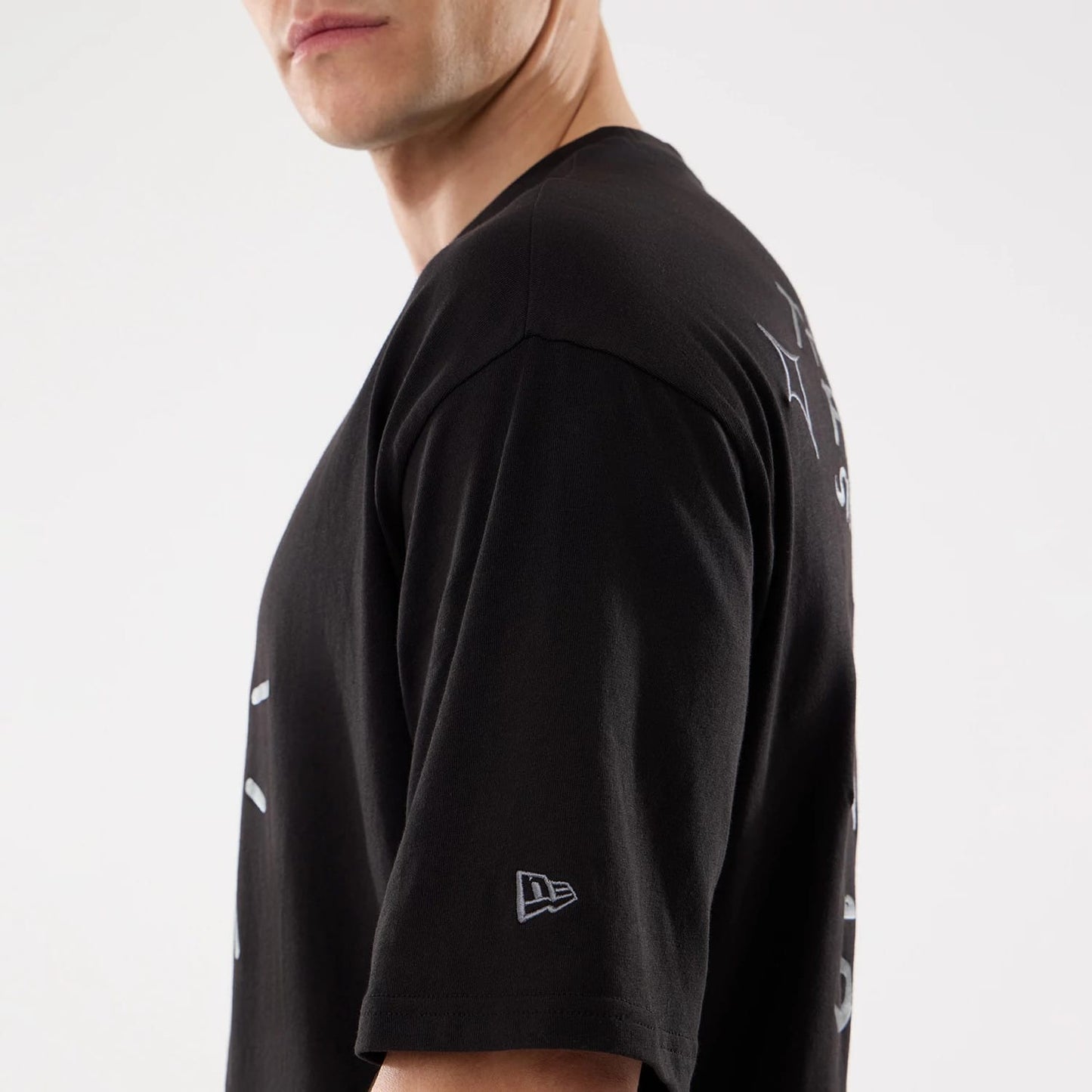 The model is wearing this New Era 59FIFTY Day Graphic T-Shirt in black. 6