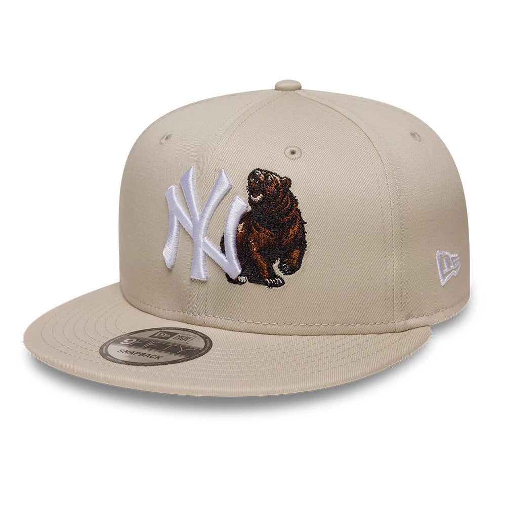 Yankees MLB Outdoor Icon Light Beige New Era 9FIFTY Snapback Adjustable Cap, three-quarter view showing the raised white NY logo and a detailed brown bear embroidery on the front panel, with the New Era flag logo on the left side.