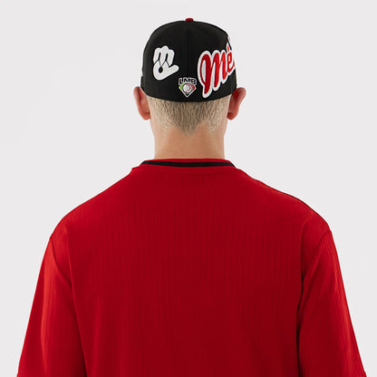 New Era Mexico Diablos LMB Red Oversized T-Shirt, back view on a model wearing a matching cap, showing a plain red back with vertical ribbing, and a black round neckline, contrasted against the graphics on the cap.
