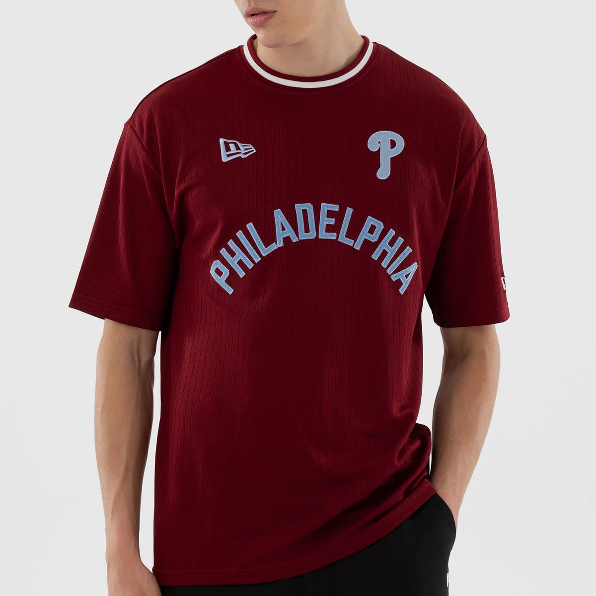 New Era Philadelphia Phillies MLB Dark Red Oversized T-Shirt, front view on-model showing the light blue embroidered Phillies P logo on the chest, arched Philadelphia lettering beneath it, and the New Era flag on the right shoulder.
