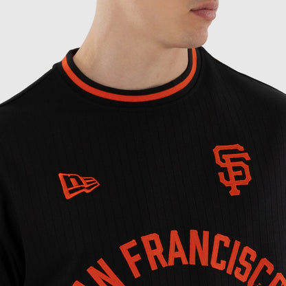 New Era San Francisco Giants MLB Black Oversized T-Shirt, front view showing the orange embroidered SF logo on the left chest, an orange New Era flag above the hem, and SAN FRANCISCO lettering across the chest, with a black and orange ribbed collar.