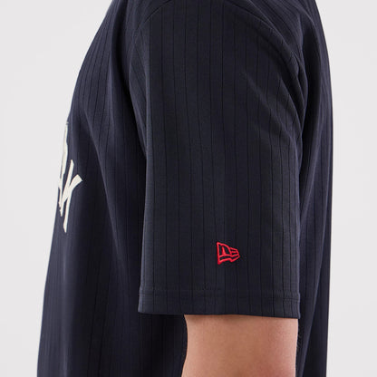 New Era New York Yankees MLB Navy Oversized T-Shirt, side view highlighting the navy pinstriped sleeve with a small red embroidered New Era logo near the hem and part of the large white Yankees lettering on the front.