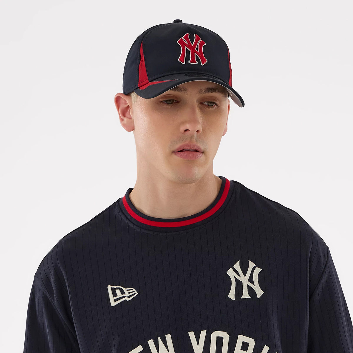 New Era New York Yankees MLB Navy Oversized T-Shirt, front view on a model with a navy base featuring a white embroidered New York Yankees logo on the chest, a red and white round collar, and a matching embroidered New Era logo on the right shoulder.