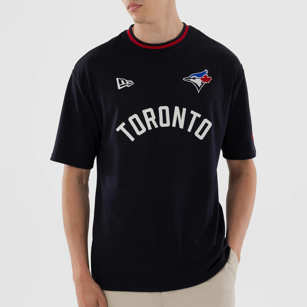 New Era Toronto Blue Jays MLB Navy Oversized T-Shirt, front view on a model showing the arched Toronto lettering across the chest, a colourful Blue Jays logo embroidered on the upper right, and a New Era logo on the upper left.