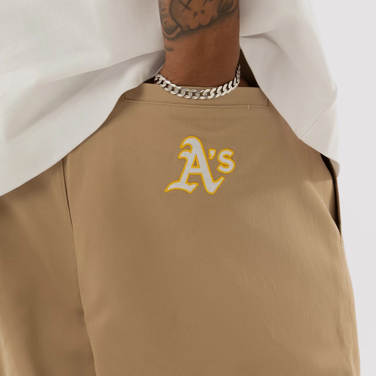 The model is wearing this MLB Athletics Chino Trousers in light beige. 3