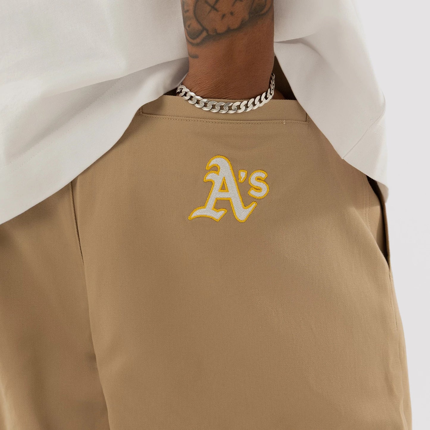 The model is wearing this MLB Athletics Chino Trousers in light beige. 3