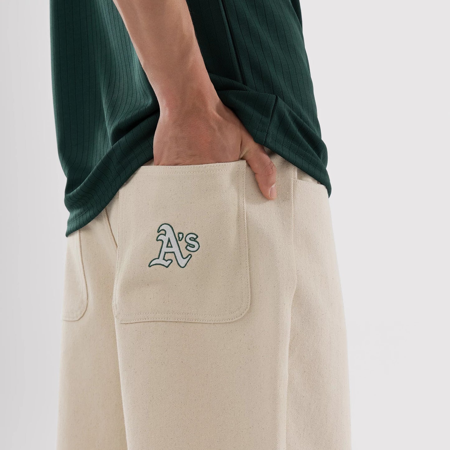 The model is wearing this MLB Jort Athletics Oversized Shorts in Cream. 3