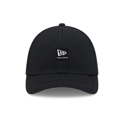 New Era Golf Rubber Patch Black New Era 39THIRTY M-Crown Stretch Fit Cap, front view showing the textured black crown with a central black and white patch logo, matching curved black visor, and stitched eyelets.
