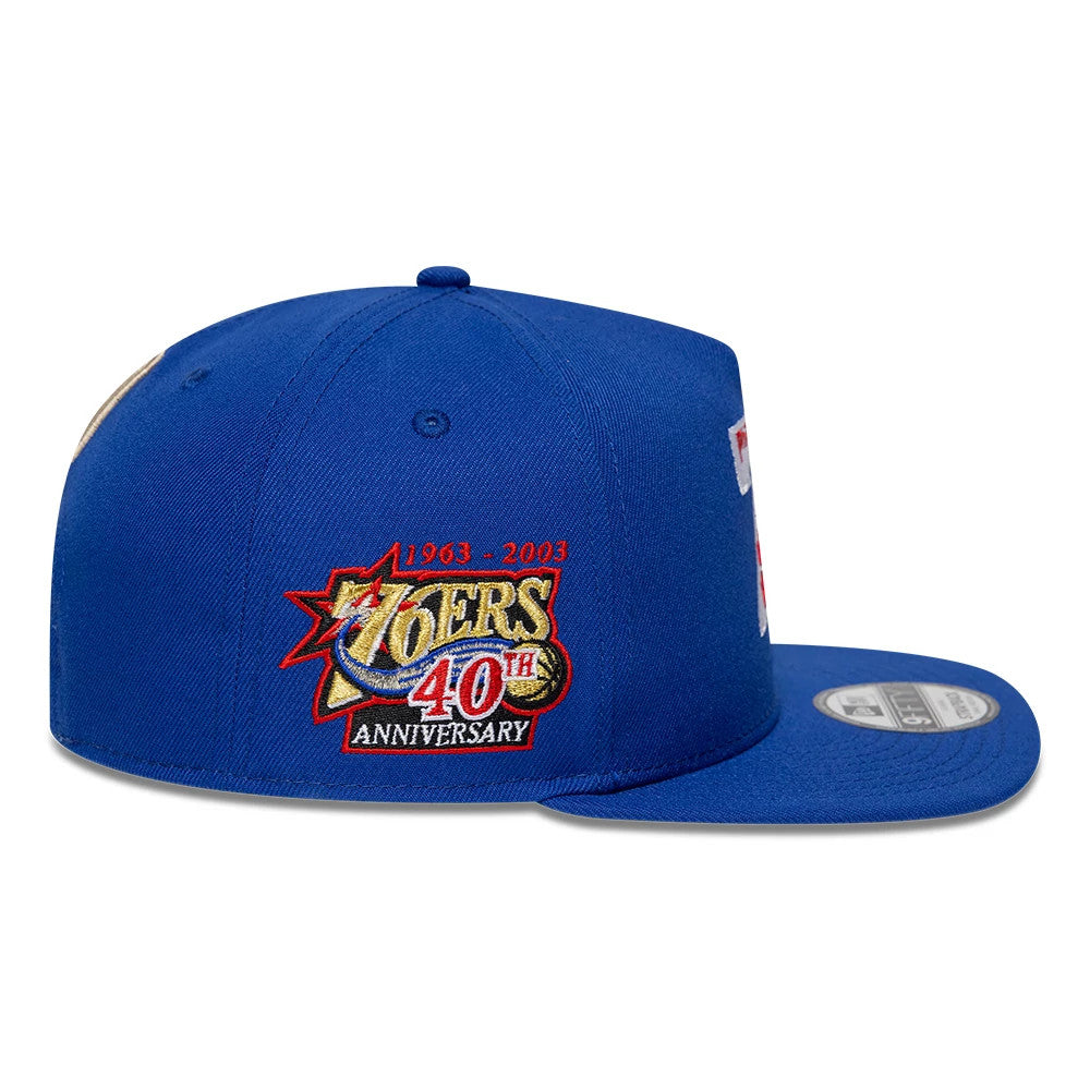 Philadelphia 76ers NBA Hardwood Classic Blue New Era 9FIFTY A-Frame Snapback Adjustable Cap, side view showing the multicoloured embroidered 76ers 40th-anniversary logo on the side panel, with a structured blue crown and flat blue visor.