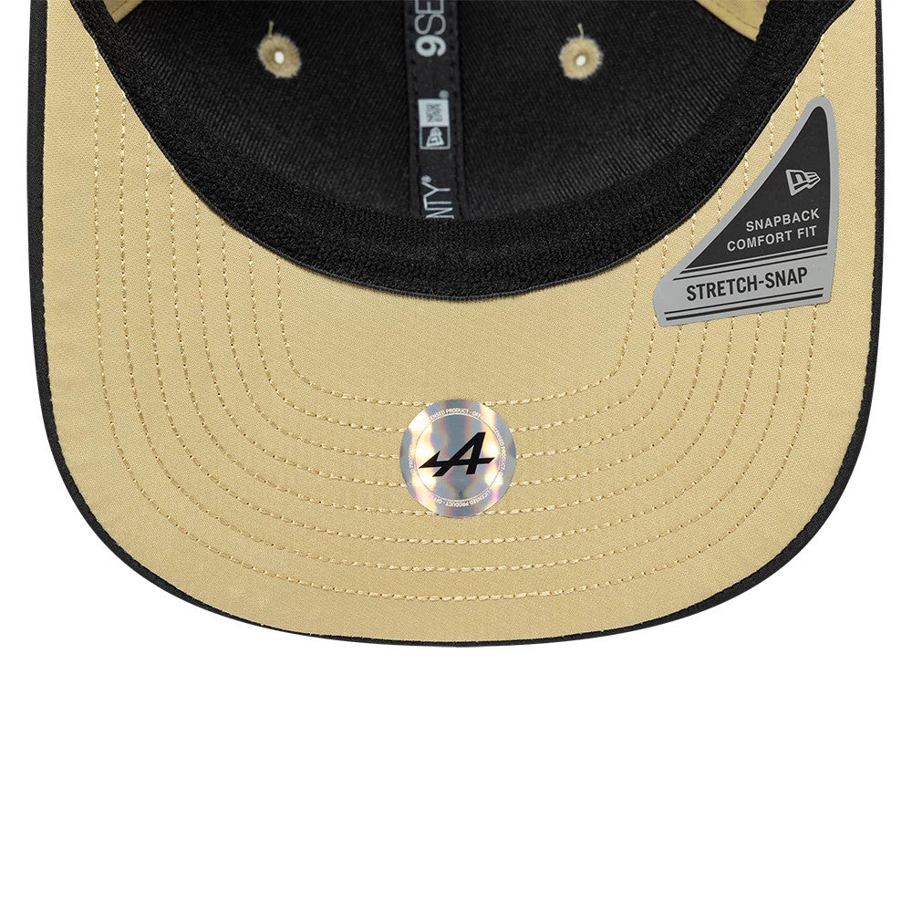 Alpine Racing Latin American Pierre Gasly Light Beige New Era 9SEVENTY Stretch Snap Adjustable Cap, inside view showing light beige undervisor with black stitching and snapback comfort fit sticker, alongside the New Era tape and black sweatband.