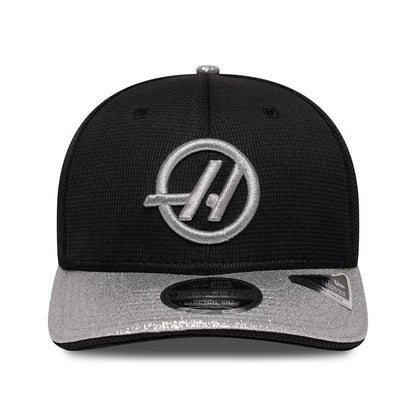 TGR Haas F1 Vegas Race Special Black New Era 9SEVENTY Stretch Snap Adjustable Cap, front view showing the raised silver embroidered Haas logo on the structured black crown, with a silver visor and a 9SEVENTY size sticker.