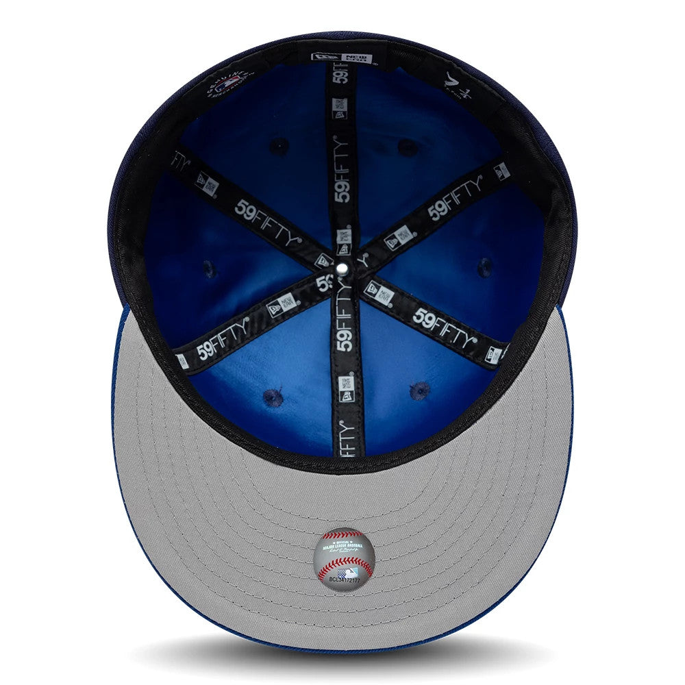 Toronto Blue Jays MLB Multi Logo Satin Lined Navy New Era 59FIFTY Fitted Cap, inside view showing black taping with white 59FIFTY logos, a blue satin lining inside the crown, and a grey undervisor with a detailed baseball sticker.