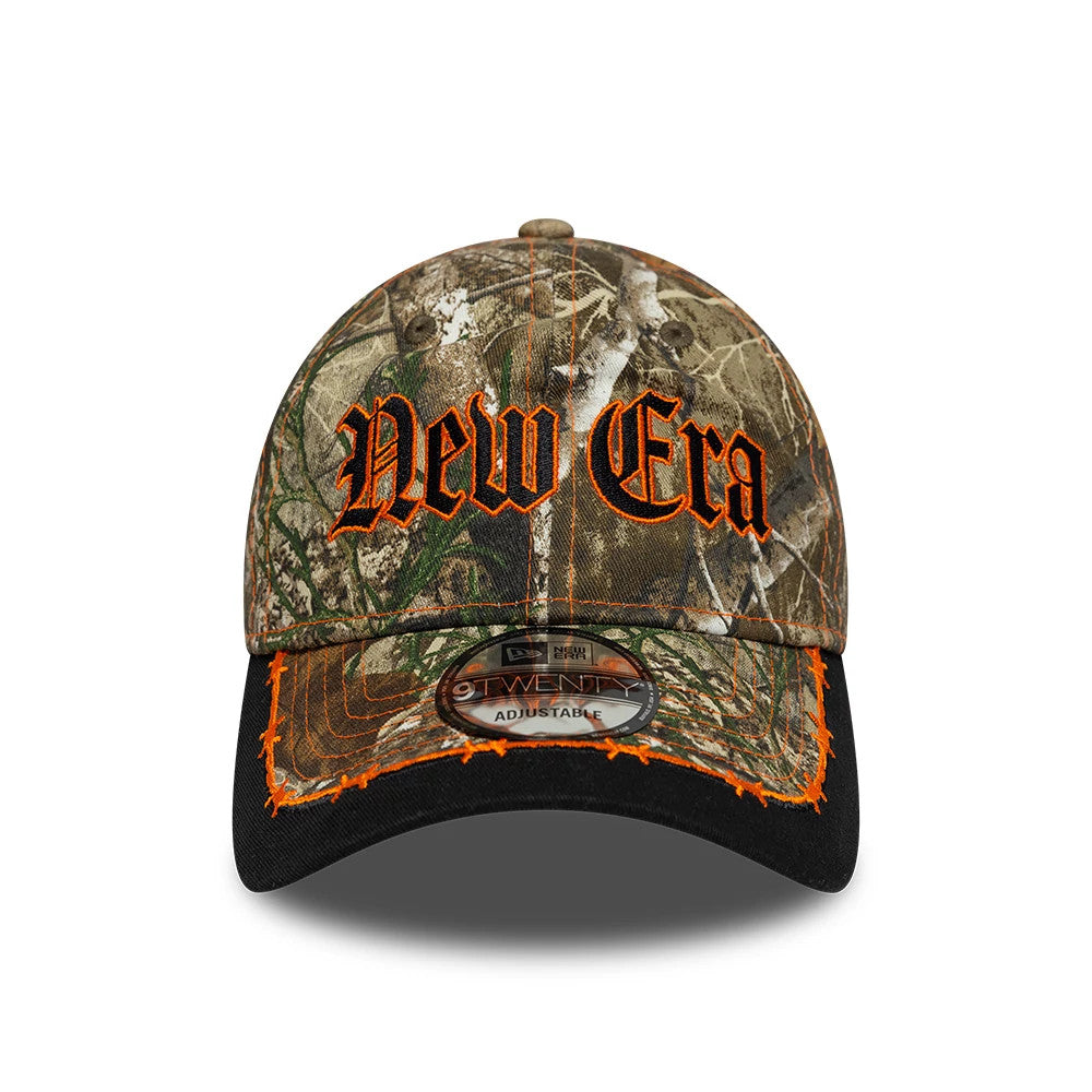 New Era Real Tree Assorted Print 9TWENTY Adjustable Cap, front view showing large orange embroidered New Era lettering on the camo front panel, orange stitching detail on the black visor, and a 9TWENTY size sticker at the centre.