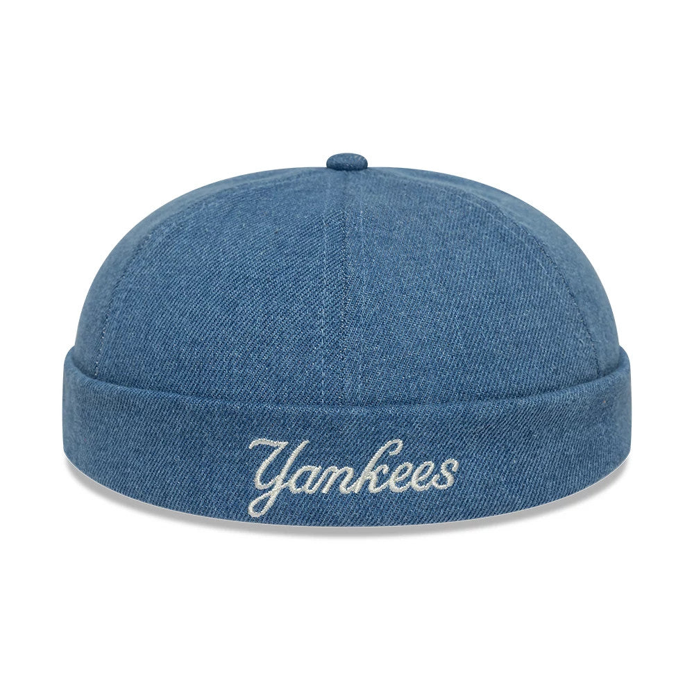 New Era New York Yankees MLB Denim Skully Pastel Blue Docker Adjustable Cap, rear view showing white Yankees script embroidery centred on the rolled denim cuff, with a flat crown design and a top button in matching pastel blue fabric.
