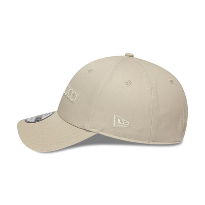 Colucci X New Era Light Beige 9FORTY Adjustable Cap, side view showing the white embroidered New Era flag logo on the left side, the slightly curved visor with a 9FORTY size sticker, and the structured light beige crown.