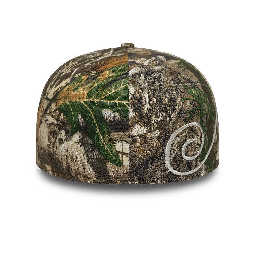 New Era Side Script Realtree Camo Low Profile 59FIFTY Fitted Cap, rear view showing the intricate white side script embroidery on the right back panel, with a top button and eyelets on a textured camouflage crown featuring green foliage details.