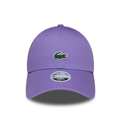 Womens Lacoste X New Era Purple 9FORTY Adjustable Cap, front view showing the green embroidered Lacoste crocodile logo on the structured purple crown, a curved purple visor, and the 9FORTY size sticker at the centre.