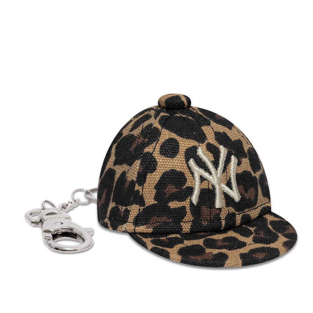 New Era New York Yankees MLB Leo Mini Cap Black Key Chain, side view featuring a leopard print pattern on the structured crown and visor, with the NY logo embroidered in white on the front panel and a silver key chain attachment.