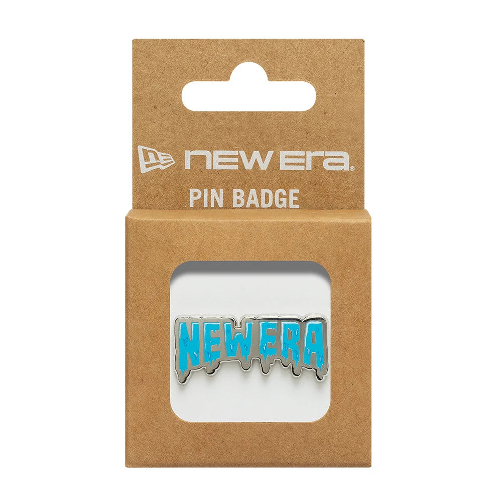 New Era Drip Script Silver Pin Badge, front view displaying a blue drip script NEW ERA lettering highlighted against a silver outline, packaged in a brown card backing with a printed New Era logo and PIN BADGE text above the pin.