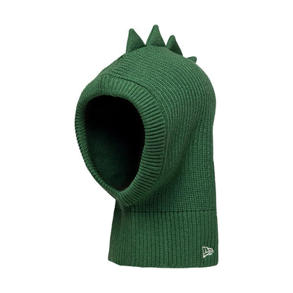 Child New Era Dino Dark Green Balaclava Hat, side view showing the ribbed knit texture with dinosaur-inspired spikes along the top for a playful look, and the New Era flag logo embroidered on the lower edge.