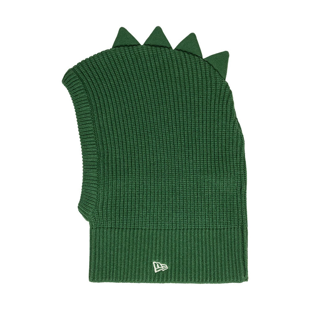 Child New Era Dino Dark Green Balaclava Hat, side view showing the ribbed dark green knit texture with soft triangular dino spikes along the top, and a white embroidered New Era flag logo on the cuff at the side.