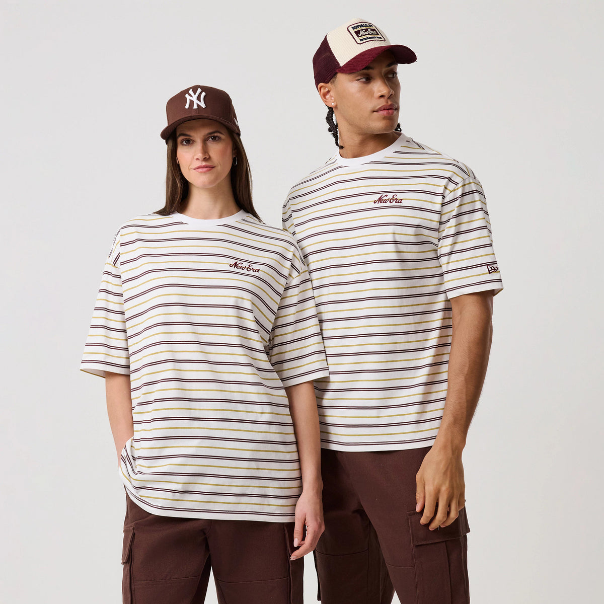 New Era Stripe White T-Shirt, front view on-model showing a relaxed fit with light brown and black stripes across a white base, an embroidered New Era logo on the left chest, and a New Era logo tag on the left sleeve.