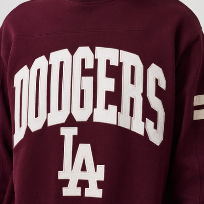New Era LA Dodgers MLB Arch Graphic Dark Purple Crew Neck Sweater, front view showing large white embroidered Dodgers lettering across the chest, contrasting with the deep purple fabric, and white LA logo below, with striped on the sleeves.