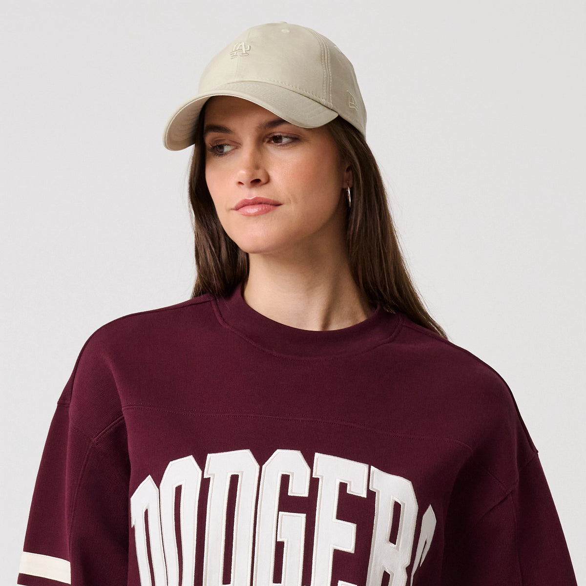 New Era LA Dodgers MLB Arch Graphic Dark Purple Crew Neck Sweater, on-model view showing the large white Dodgers lettering across the chest, the ribbed collar and cuffs, and two contrasting white stripes around the upper sleeves.