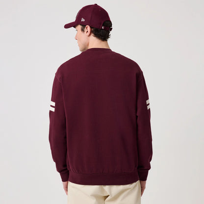 New Era LA Dodgers MLB Arch Graphic Dark Purple Crew Neck Sweater, back view on a model with a matching dark purple cap, showing two white stripes on each sleeve and a ribbed waistband, highlighting the sweater's relaxed fit.