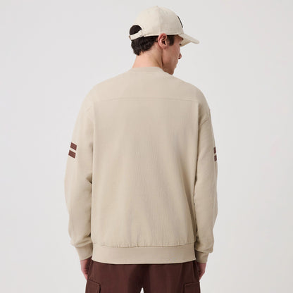 The model is wearing this MLB Arch Graphic Philadelphia Phillies Crew Neck Sweater in light beige. 2